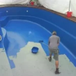Homem trabalhando realizando a manutenção da piscina de fibra